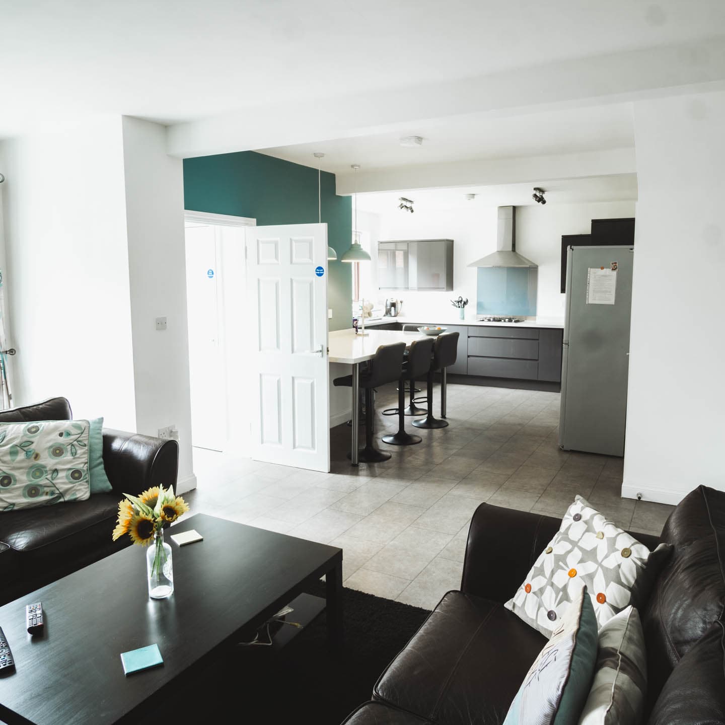 Inside of house living area with kitchen in background